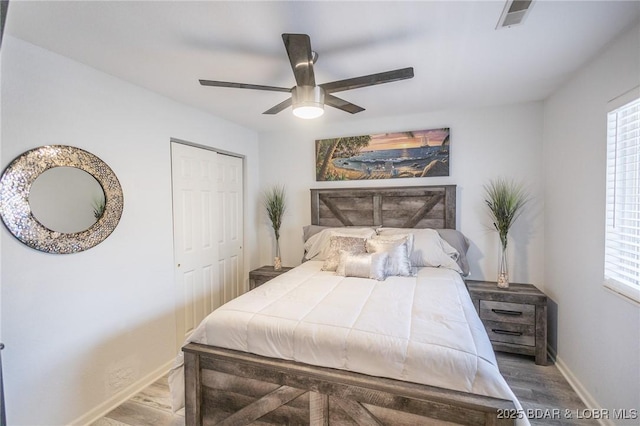 bedroom featuring hardwood / wood-style flooring, ceiling fan, and a closet