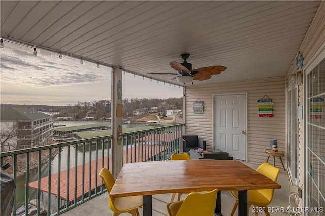 balcony at dusk featuring ceiling fan