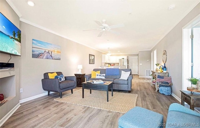 living room with crown molding, ceiling fan, and hardwood / wood-style flooring