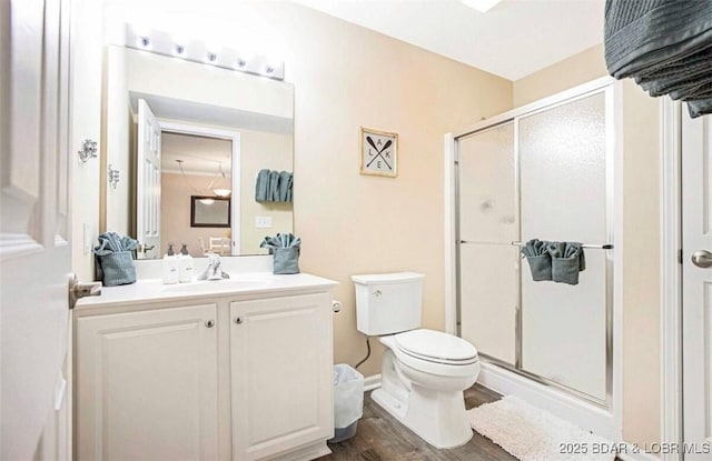 bathroom with walk in shower, vanity, toilet, and hardwood / wood-style flooring