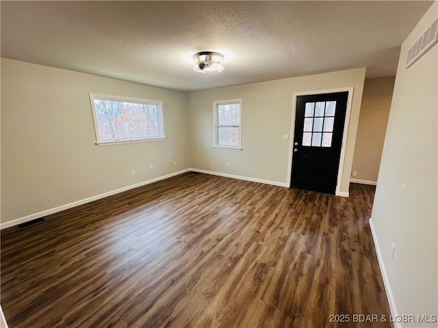 foyer entrance featuring dark wood-type flooring and a textured ceiling