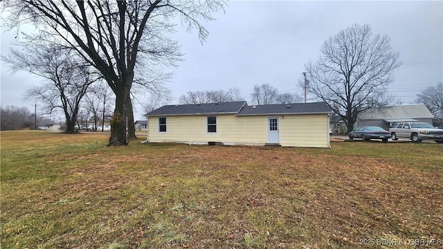 rear view of house featuring a lawn