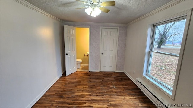 unfurnished bedroom with a textured ceiling, dark wood finished floors, baseboard heating, baseboards, and connected bathroom