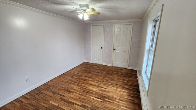 unfurnished bedroom with crown molding, hardwood / wood-style flooring, a textured ceiling, baseboards, and a ceiling fan