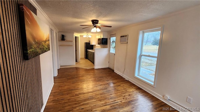 unfurnished living room featuring a textured ceiling, crown molding, dark wood-style flooring, ceiling fan, and baseboards