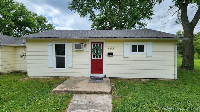 view of front of property featuring a front lawn and roof with shingles