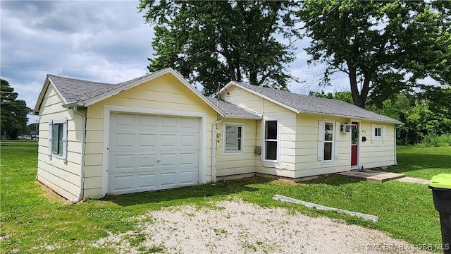 ranch-style house with driveway, a front yard, and a shingled roof