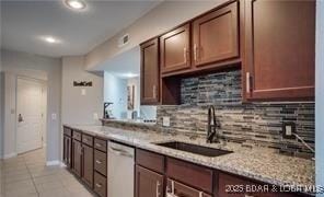 kitchen featuring sink, light tile patterned floors, dishwasher, light stone countertops, and decorative backsplash