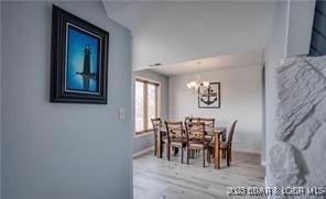 dining area with hardwood / wood-style floors and a notable chandelier