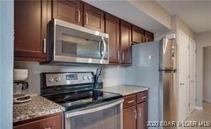 kitchen featuring appliances with stainless steel finishes and light stone countertops