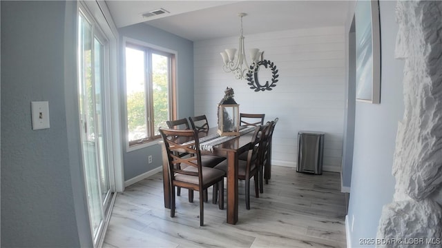 33 Crow Ct Unit 2E, Lake Ozark, MO 65049 - dining area featuring a chandelier, healthy amount of natural light, and light wood finished floors