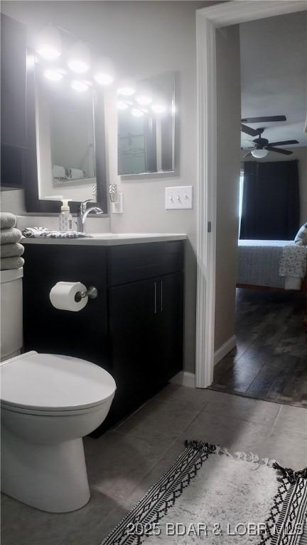 bathroom featuring vanity, toilet, and ceiling fan