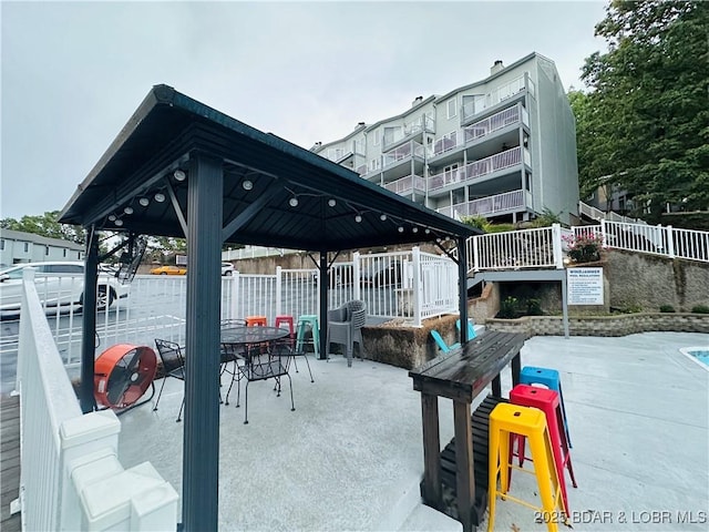 33 Crow Ct Unit 2E, Lake Ozark, MO 65049 - dock area featuring a gazebo, fence, a patio, and outdoor dining space