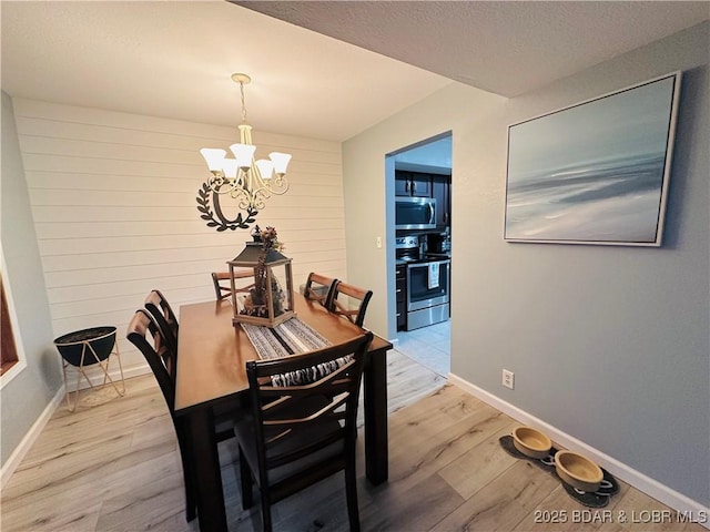 33 Crow Ct Unit 2E, Lake Ozark, MO 65049 - dining space with a chandelier, light wood-style flooring, and a textured ceiling