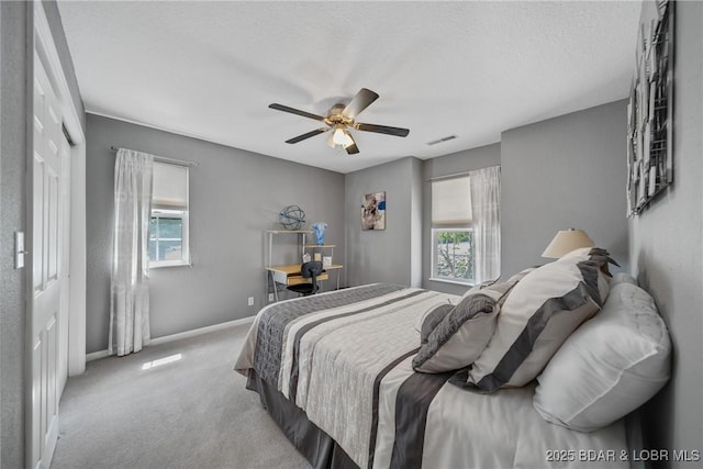 bedroom featuring light carpet, a textured ceiling, and ceiling fan