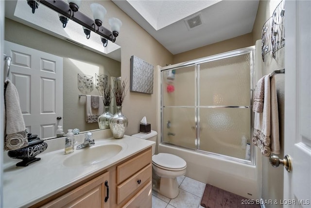 full bathroom with toilet, shower / bath combination with glass door, a skylight, vanity, and tile patterned flooring