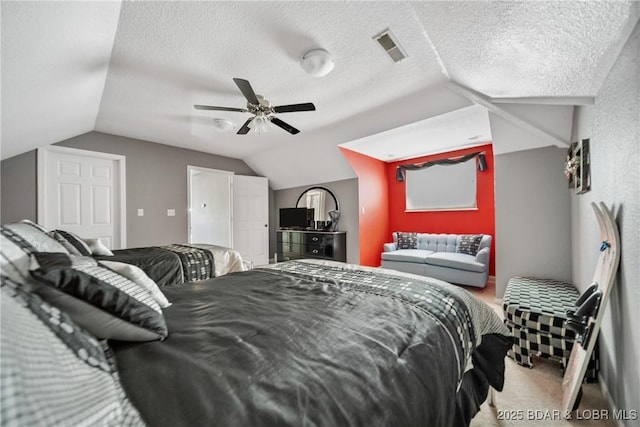 bedroom featuring carpet floors, ceiling fan, vaulted ceiling, and a textured ceiling