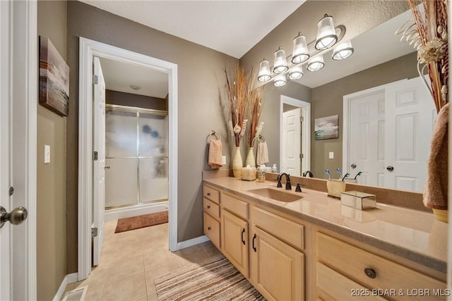 bathroom with vanity, a shower with shower door, and tile patterned floors