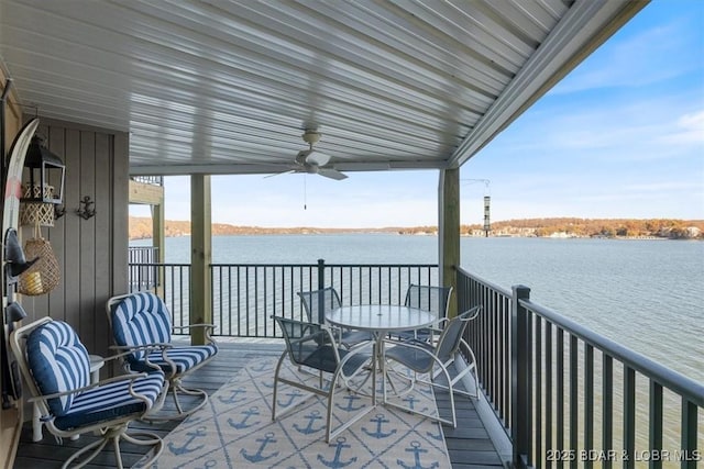 deck with a water view and ceiling fan