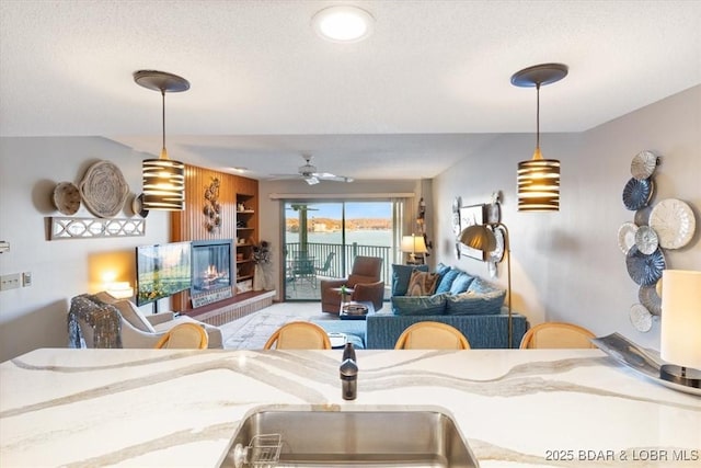 living room featuring ceiling fan and a textured ceiling