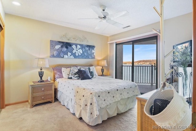 bedroom featuring ceiling fan, light colored carpet, access to exterior, and a water view