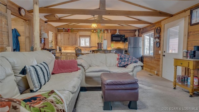 carpeted living room featuring lofted ceiling with beams and wooden walls