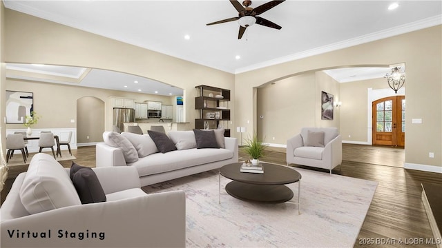 living room with hardwood / wood-style flooring, ornamental molding, and ceiling fan