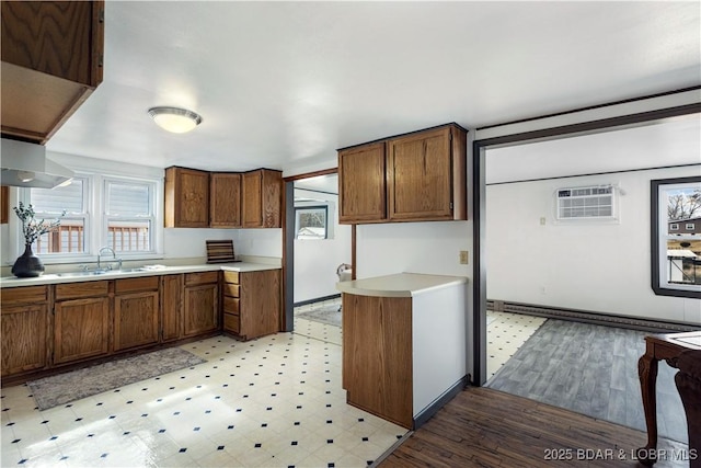 kitchen featuring a wall mounted air conditioner, sink, and a baseboard heating unit