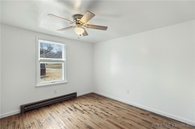 spare room featuring ceiling fan, light wood-type flooring, and baseboard heating