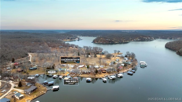 aerial view at dusk featuring a water view