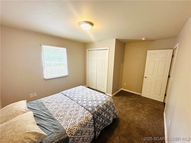 bedroom with dark colored carpet, a textured ceiling, and a closet