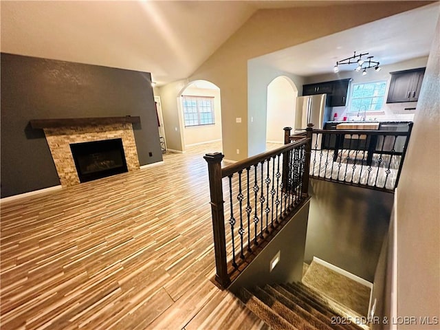 stairway featuring lofted ceiling, sink, and hardwood / wood-style floors