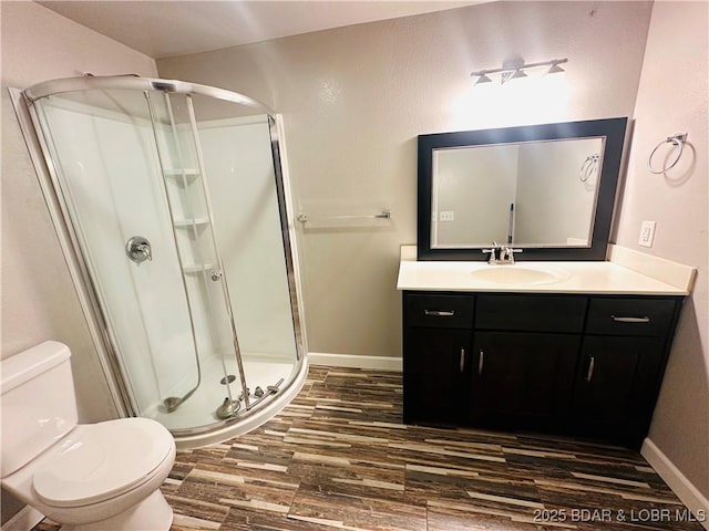 bathroom with an enclosed shower, vanity, hardwood / wood-style flooring, and toilet