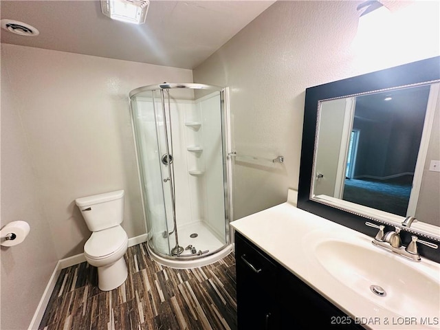 bathroom featuring walk in shower, hardwood / wood-style floors, vanity, and toilet