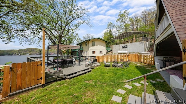 view of yard featuring a deck with water view and an outdoor fire pit