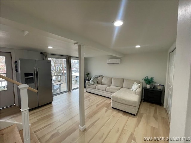 living area with a wall unit AC, plenty of natural light, light wood-style flooring, and recessed lighting