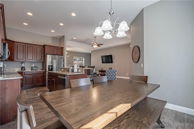 dining room featuring sink, ceiling fan with notable chandelier, and dark hardwood / wood-style flooring