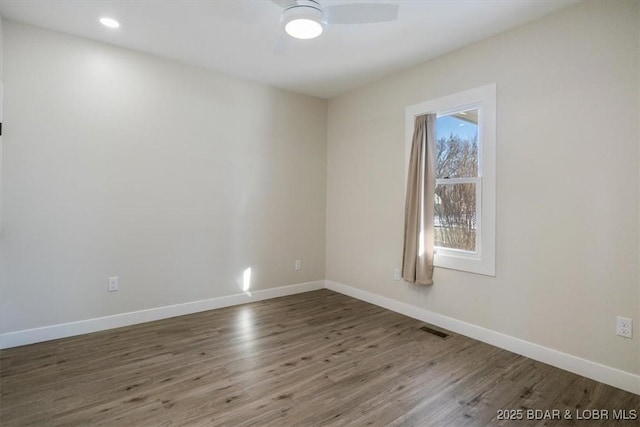 empty room with dark hardwood / wood-style floors and ceiling fan