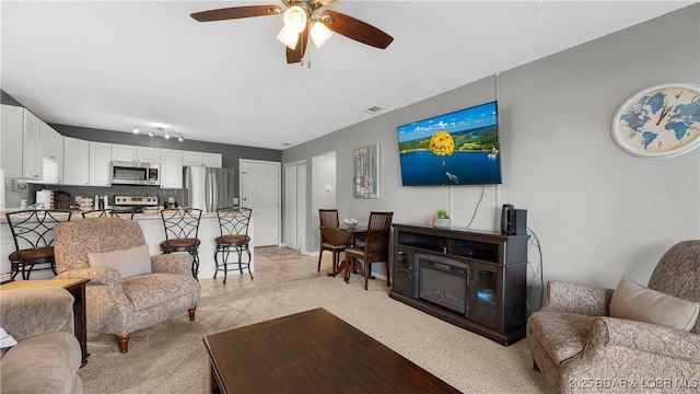 carpeted living room with ceiling fan