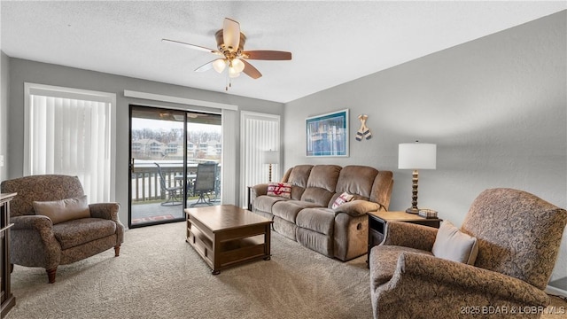 living room with ceiling fan, carpet floors, and a textured ceiling