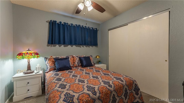 carpeted bedroom featuring ceiling fan, a closet, and a textured ceiling