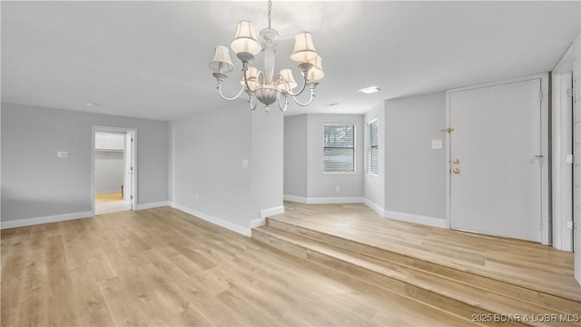 interior space featuring an inviting chandelier and light hardwood / wood-style flooring