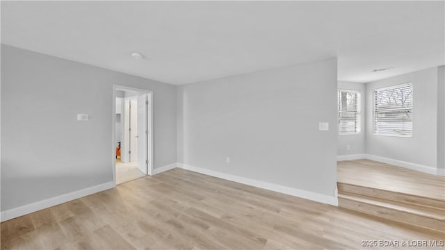 empty room with light hardwood / wood-style flooring