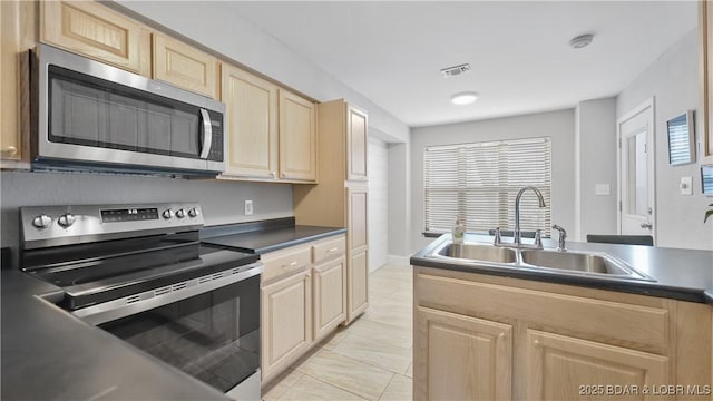 kitchen featuring sink, light brown cabinets, and appliances with stainless steel finishes