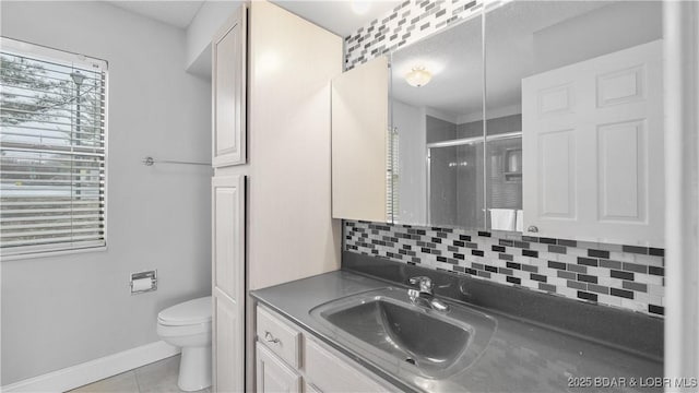 bathroom with walk in shower, tile patterned floors, toilet, vanity, and decorative backsplash