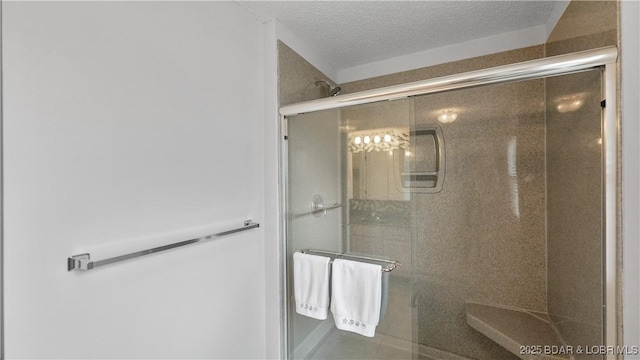 bathroom with an enclosed shower and a textured ceiling