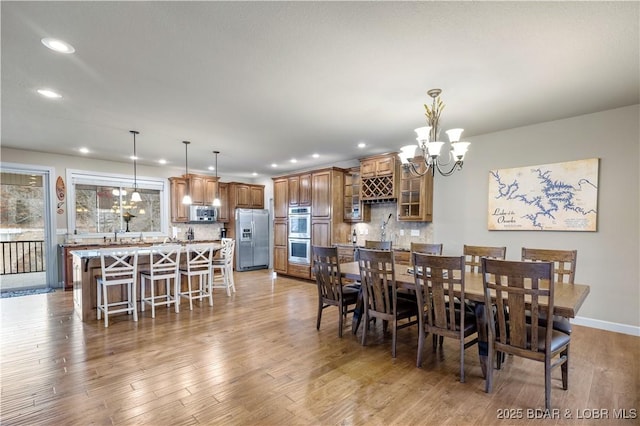 dining area featuring a notable chandelier and light wood-type flooring