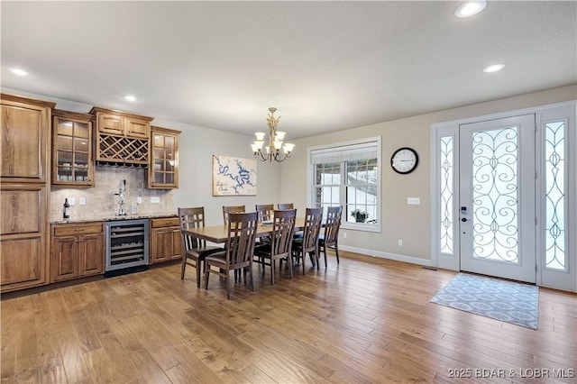 27112 White Horse Cir, Rocky Mount, MO 65072 - dining area with beverage cooler, light wood-style floors, a chandelier, bar with sink, and recessed lighting