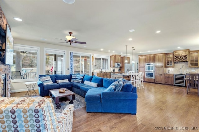 27112 White Horse Cir, Rocky Mount, MO 65072 - living area featuring beverage cooler, light wood-type flooring, bar area, recessed lighting, and ceiling fan