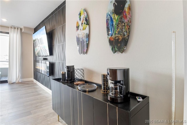 bar featuring light wood-style flooring and baseboards